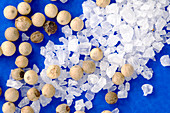 Salt crystals and peppercorns
