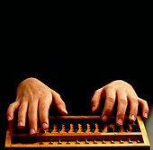 Hands carrying out a calculation on an abacus
