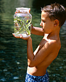 Boy holding jar of pond water