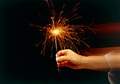 Hand holding a sparkler firework