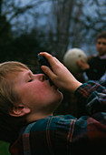 Young boy using an aerosol inhaler for asthma