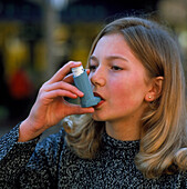 Teenager using an aerosol inhaler for asthma