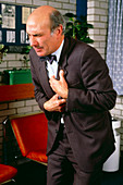 Man with angina clutching his chest