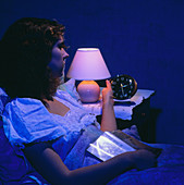 Insomnia woman in bed looking at clock
