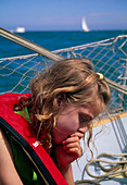 Young girl suffering from seasickness in a boat