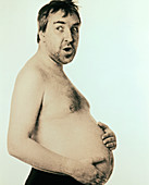 Obese man holding his bare belly