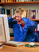 Stressed woman shouting at an office computer