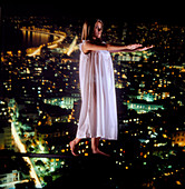 Abstract image of sleepwalking woman above a city
