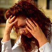 Depressed woman holds her head in her hands
