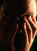 Stressed or depressed man holds his eyes
