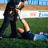 Physiotherapist stretching player's calf