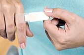 Woman applying a sticking plaster