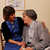 District nurse comforts an elderly patient