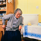 Elderly woman has difficulty rising from chair