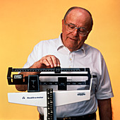 Elderly man standing on a weighing scale