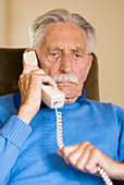 Elderly man using a telephone