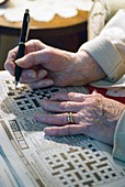 Elderly person doing a crossword