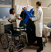 Disabled woman being hoisted into dental chair
