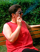 Overweight woman smoking a cigarette