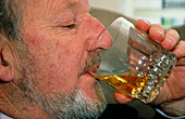Profile of an elderly man drinking alcohol