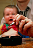 Passive smoking: man smokes while holding baby