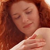 Woman sticks a nicotine patch onto her arm