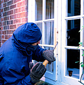 Burglar breaking into a house