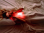 Woman awake in bed with chest or abdominal pain