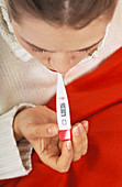 Feverish woman taking her temperature