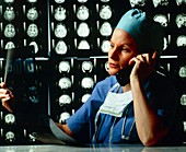 Doctor on telephone viewing MRI scans