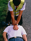 Ambulanceman giving cardiac massage to man
