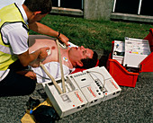 Ambulanceman using portable defibrillator