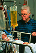 Woman coma patient in intensive care,with visitor
