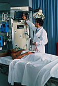 Doctor monitoring a male intensive care patient