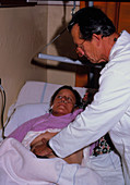 Doctor examining abdomen of woman in hospital