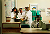Hospital staff with patient records at workstation