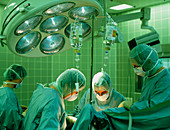 Masked surgeons conduct a surgical operation