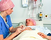 Nurse preparing female patient for operation