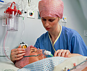 Woman with oxygen mask in post-op recovery room