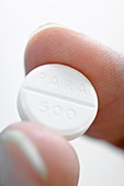 Woman holding a paracetamol tablet