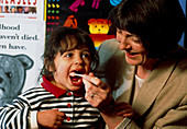 Child having oral swab test for measles/rubella