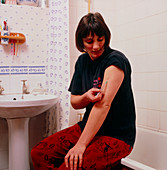 Diabetic woman injecting herself with insulin