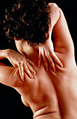 Woman affected by shoulder pain doing self-massage