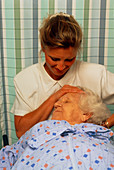 Elderly woman receives a head and neck massage