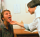 Acupuncturist examining a patient's tongue