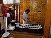 Dispensing Chinese herbal medicine at a Pharmacy