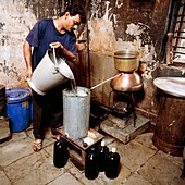 Man prepares herbal oils in Indian pharmacy