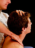 Osteopath manipulating patient's head and neck