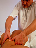 Osteopath treating the thigh of a patient