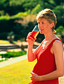 Pregnant woman drinking a glass of juice